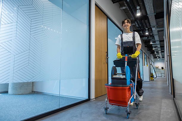 Cleaning personnel. Dark-haired young woman in uniform with a cart of cleaning equipment